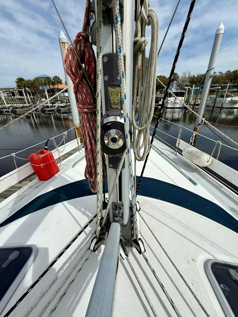Slide: The Image of Deck view of a 1998 Hunter 410 sailboat with ropes and marina background. - 22