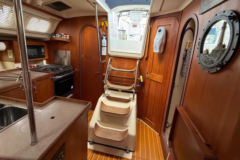 Slide: The Image of Interior of 1998 Hunter 410 sailboat with wooden cabinetry and compact kitchen area. - 25