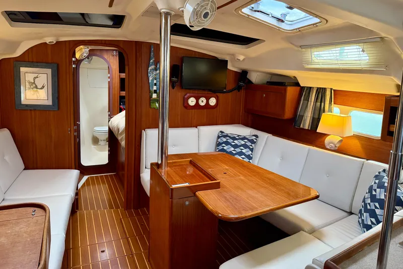 Slide: The Image of Interior of a 1998 Hunter 410 sailboat with cozy seating and wooden finishes. - 26