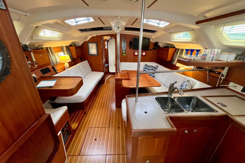 Slide: The Image of Interior of a 1998 Hunter 410 sailboat with wood finish and cozy seating area. - 28