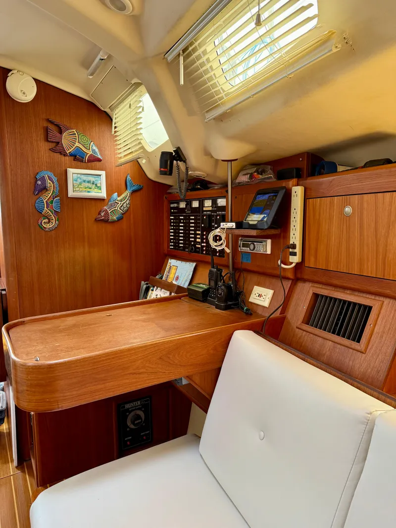 Slide: The Image of Interior of a 1998 Hunter 410 sailboat with wooden furnishings and navigation equipment. - 29