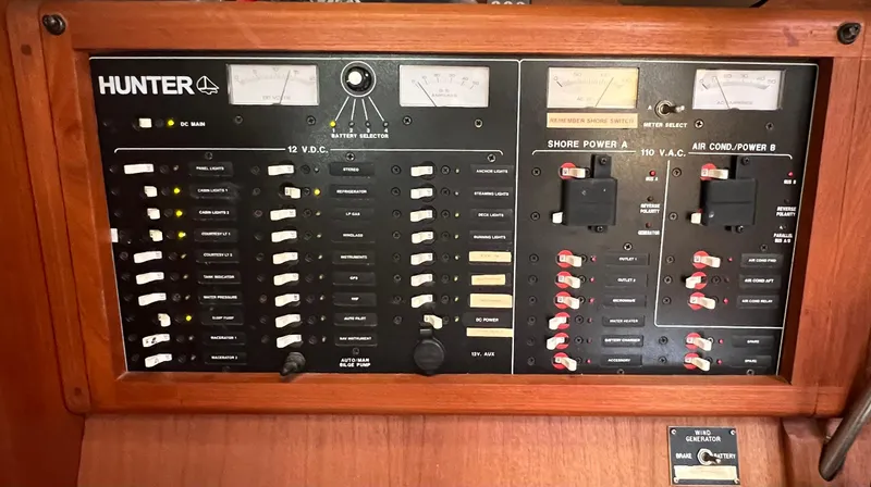 Slide: The Image of Electrical control panel of a 1998 Hunter 410 sailboat with various switches and meters. - 31