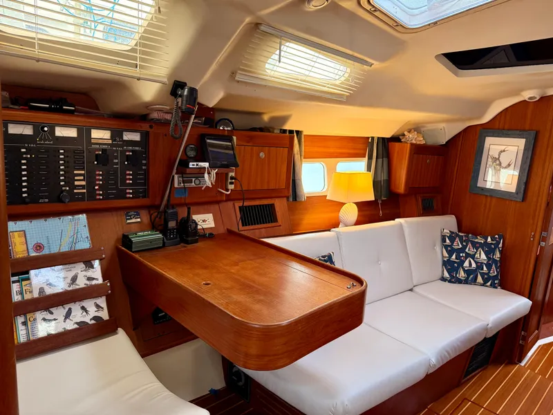 Slide: The Image of Cozy 1998 Hunter 410 yacht interior with wood paneling and white seating. - 33