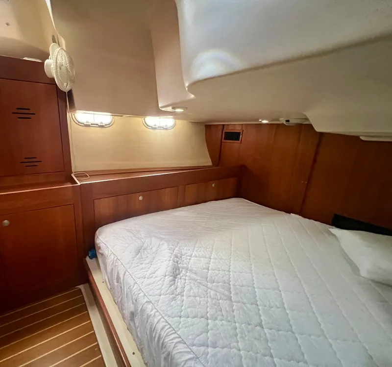 Slide: The Image of Cozy cabin interior of 1998 Hunter 410 sailboat with wooden furnishings and a comfortable bed. - 37