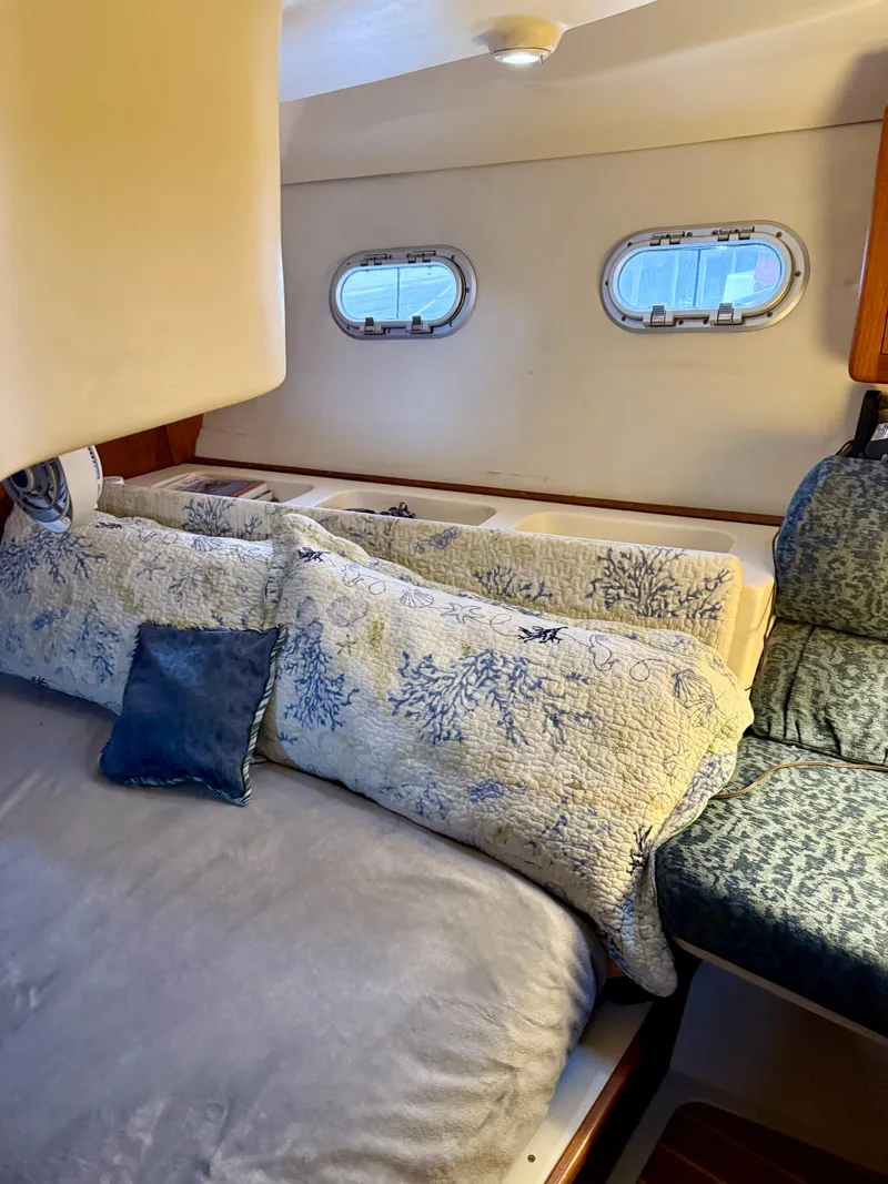 Slide: The Image of Cozy cabin interior of 1998 Hunter 410 sailboat with decorative pillows and porthole windows. - 38