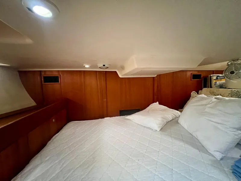 Slide: The Image of Cozy cabin interior of 1998 Hunter 410 sailboat with wooden paneling and bedding. - 39
