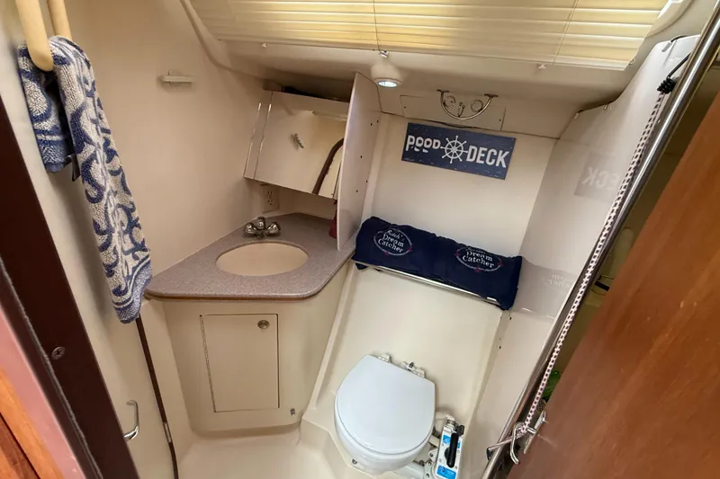 Slide: The Image of Compact bathroom in a 1998 Hunter 410 sailboat with sink, toilet, and nautical decor. - 40