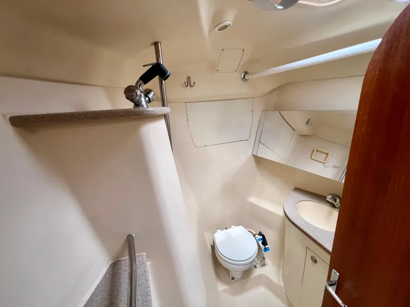 Slide: The Image of 1998 Hunter 410 yacht bathroom with toilet, sink, and mirror. - 42