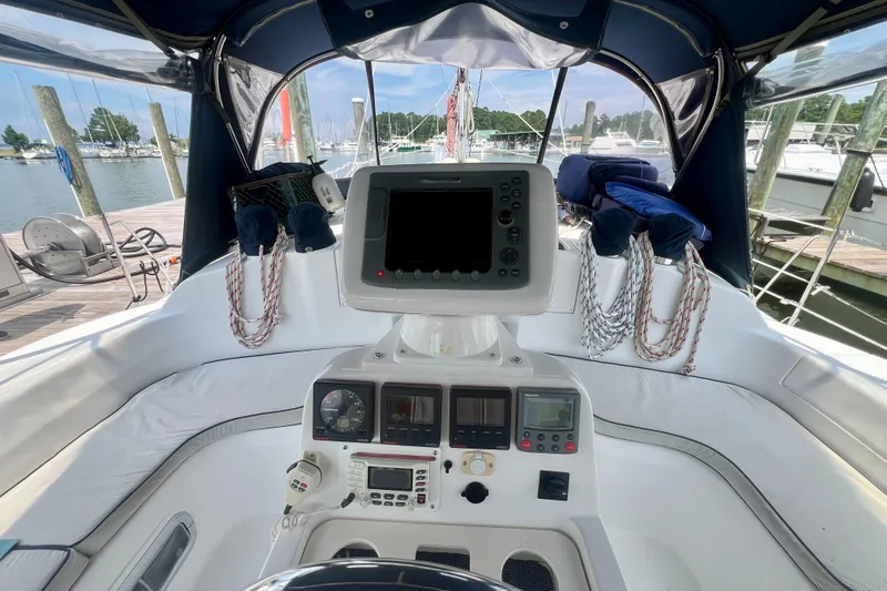 Slide: The Image of Cockpit of 1998 Hunter 410 sailboat with navigation equipment and marina view. - 7