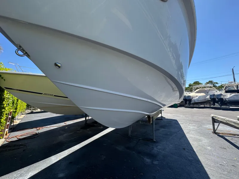 Slide: The Image of 2019 Everglades 340 Dual Console boat hull on display in a sunny outdoor setting. - 10