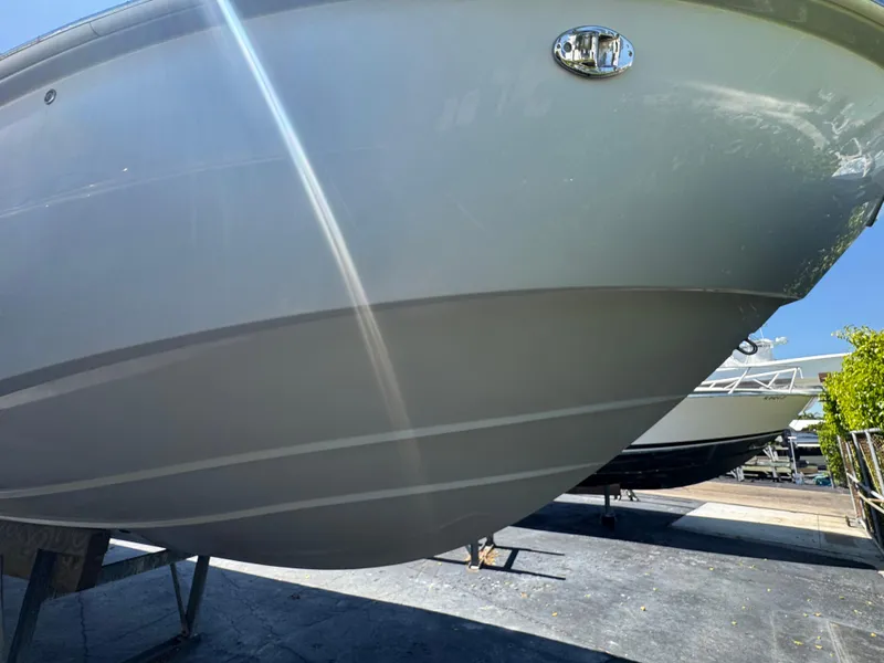 Slide: The Image of 2019 Everglades 340 Dual Console boat hull, parked outdoors on a sunny day. - 13