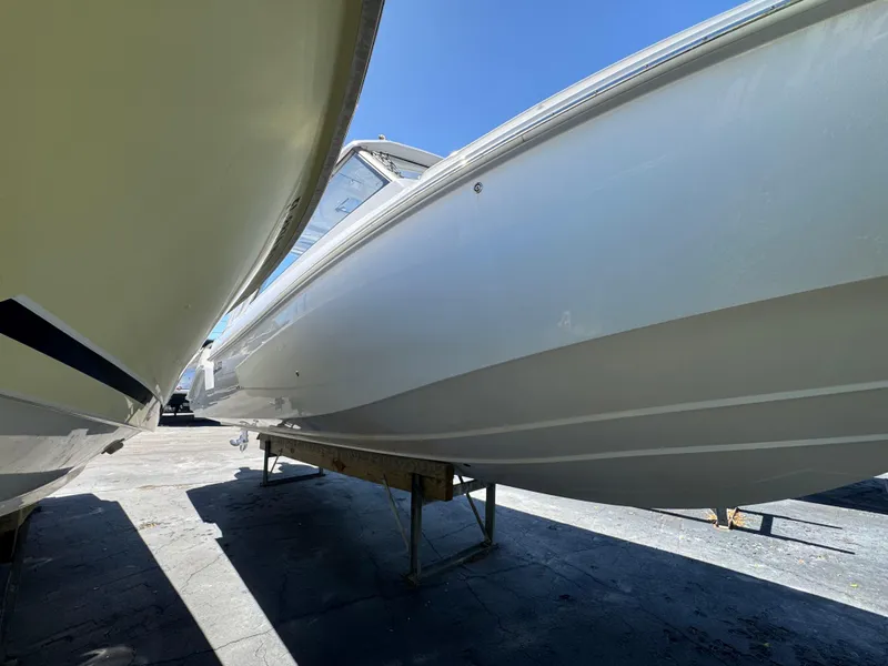 Slide: The Image of 2019 Everglades 340 Dual Console boat on stands, viewed from the side. - 14