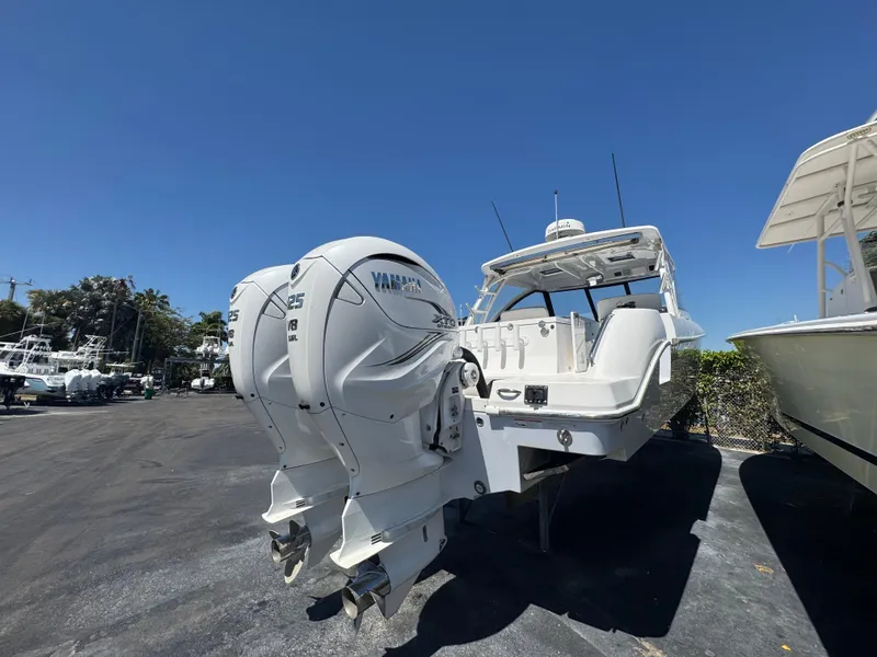 Slide: The Image of 2019 Everglades 340 Dual Console boat with twin Yamaha outboard engines, parked outdoors. - 21