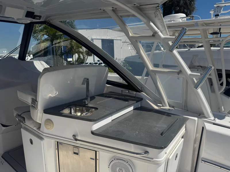 Slide: The Image of 2019 Everglades 340 Dual Console boat interior with kitchenette and sink. - 24