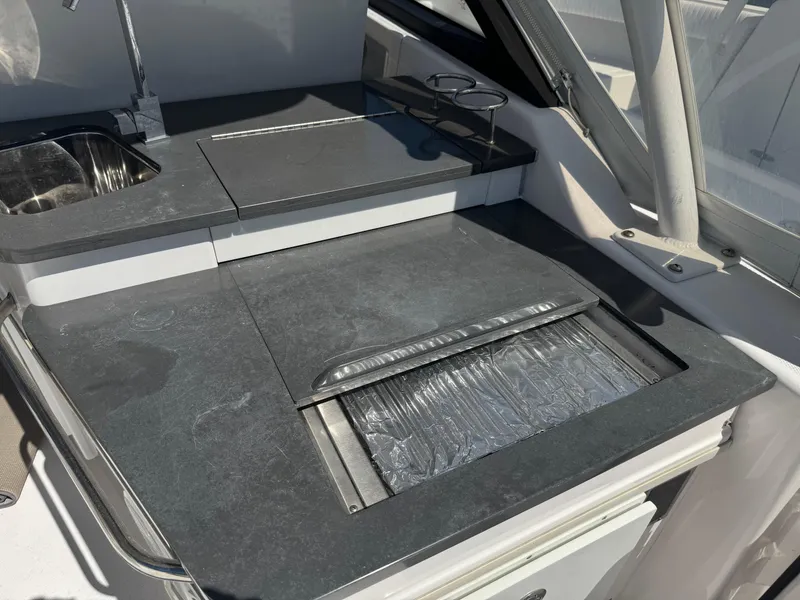 Slide: The Image of 2019 Everglades 340 Dual Console boat kitchen area with sink and countertop. - 34