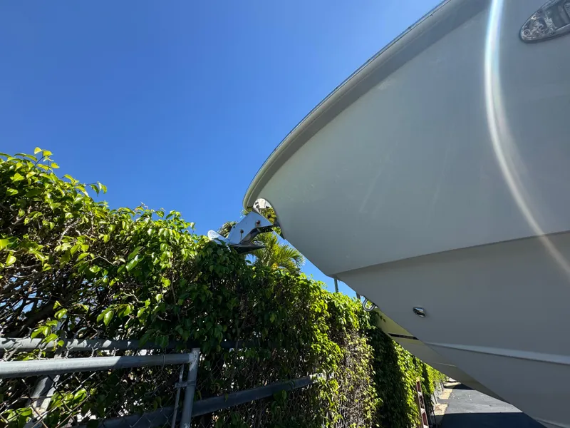 Slide: The Image of 2019 Everglades 340 Dual Console boat near green foliage under clear blue sky. - 4