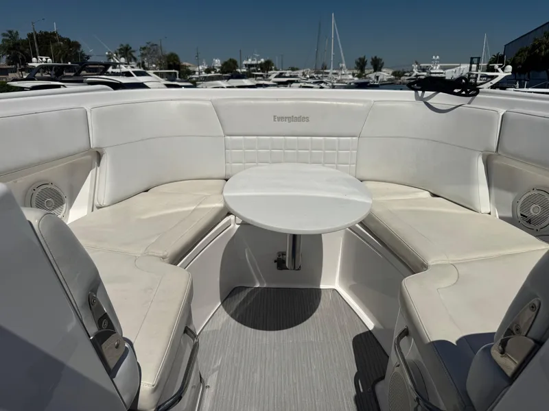 Slide: The Image of 2019 Everglades 340 Dual Console boat interior with white seating and table. - 48