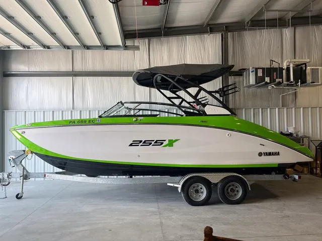 Slide: The Image of 2022 Yamaha Boats 255XD in a garage, featuring a sleek green and white design. - 1