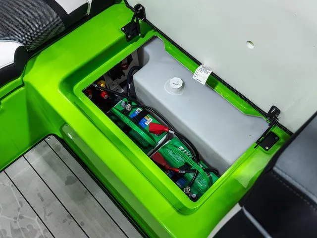 Slide: The Image of 2022 Yamaha Boats 255XD battery compartment with green casing and storage area. - 12