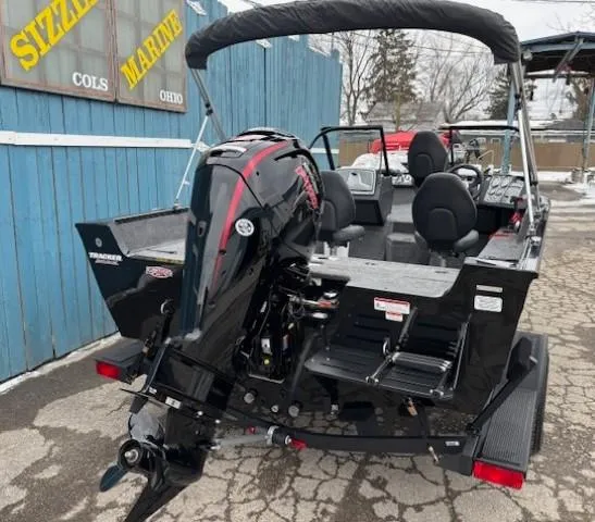 Slide: The Image of 2025 Tracker Pro Guide V-175 WT boat with outboard motor, parked outdoors. - 4