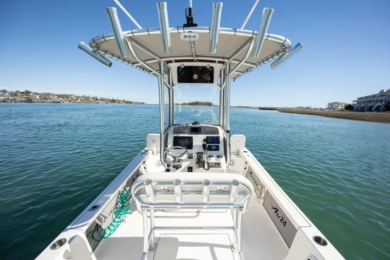 Slide: The Image of 2017 Avenger AV24 boat on calm water, featuring a central console and rod holders. - 12