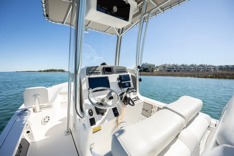 Slide: The Image of 2017 Avenger AV24 boat interior with steering console on calm water. - 14
