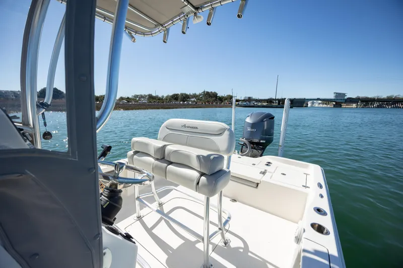 Slide: The Image of 2017 Avenger AV24 boat interior with seating, steering, and outboard motor on calm water. - 15