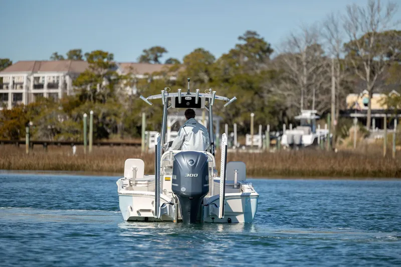 Slide: The Image of 2017 Avenger AV24 boat cruising on a calm river near a wooded shoreline. - 7