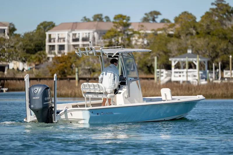 Slide: The Image of 2017 Avenger AV24 boat cruising on a calm lake with scenic background. - 8