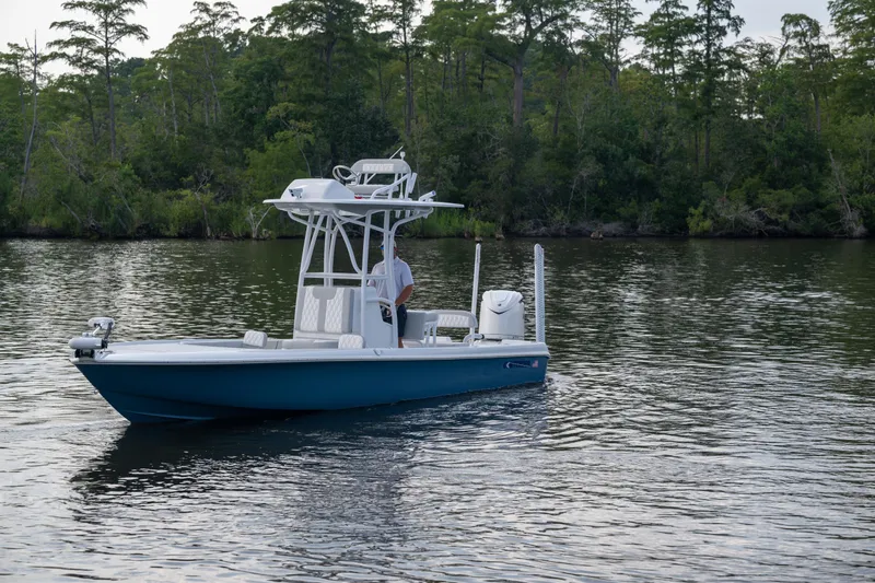 Slide: The Image of 2025 Contender 26 Bay boat on calm water with forested background. - 19