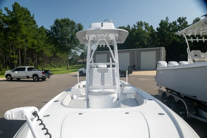 Slide: The Image of 2025 Contender 26 Bay boat in a parking lot, surrounded by trees and vehicles. - 8