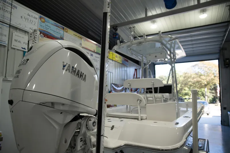 Slide: The Image of 2025 Contender 26 Bay boat with Yamaha engine in a garage setting. - 10