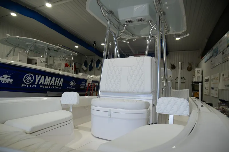 Slide: The Image of 2025 Contender 26 Bay boat interior with white seating, displayed in a showroom. - 3