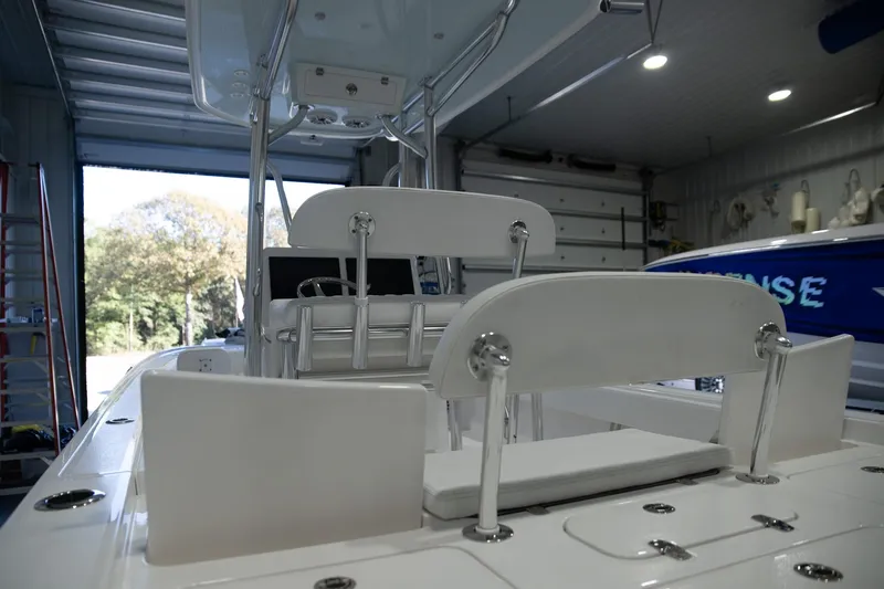 Slide: The Image of 2025 Contender 26 Bay boat interior in a garage, showcasing seating and storage features. - 6