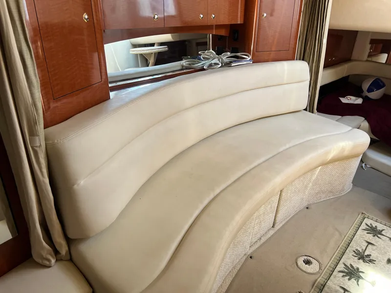 Slide: The Image of 2004 Sea Ray 340 Sundancer interior with curved beige seating and wooden cabinetry. - 14