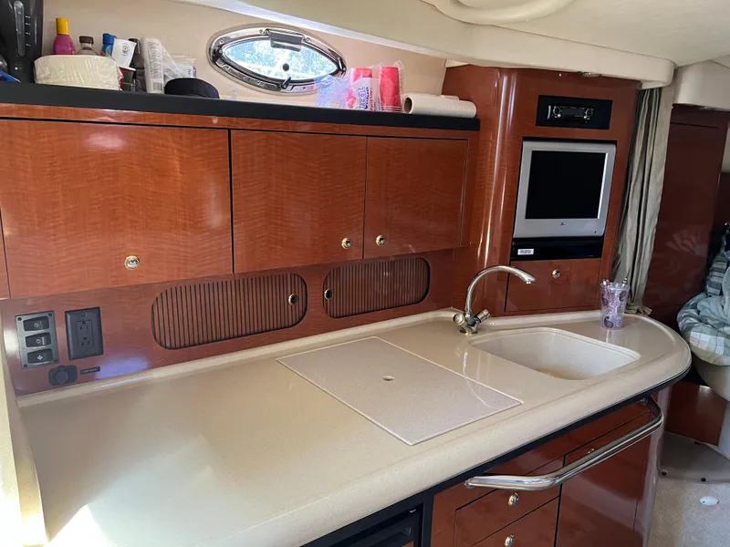 Slide: The Image of Interior of 2004 Sea Ray 340 Sundancer with kitchenette, sink, and TV. - 16