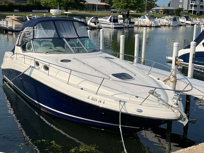 Slide: The Image of 2004 Sea Ray 340 Sundancer docked at a marina, featuring sleek design and blue hull. - 3