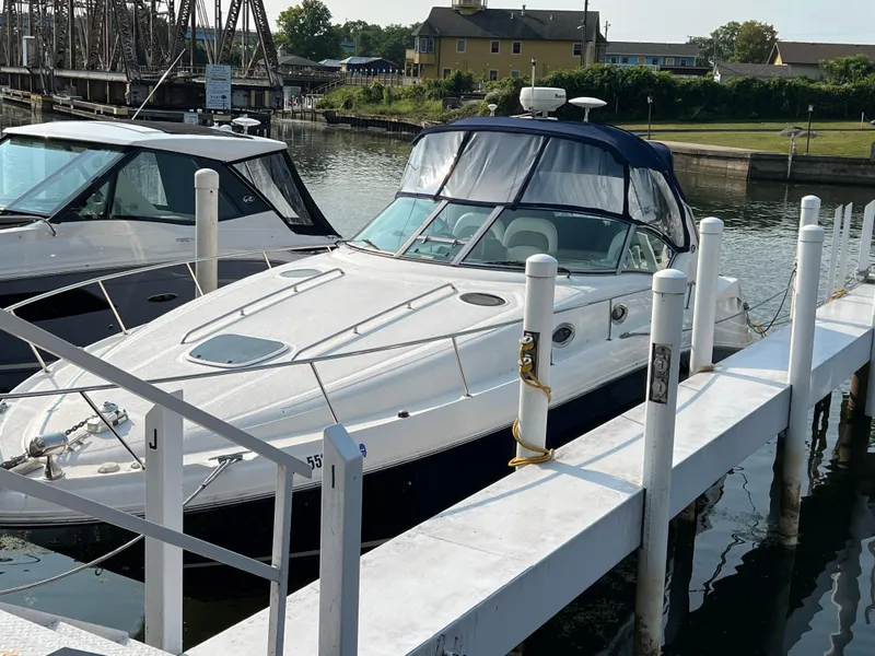 Slide: The Image of 2004 Sea Ray 340 Sundancer docked at marina, featuring sleek design and spacious deck. - 6
