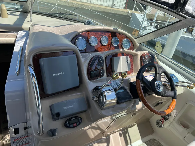 Slide: The Image of 2004 Sea Ray 340 Sundancer helm with Raymarine electronics and wood-accented dashboard. - 7