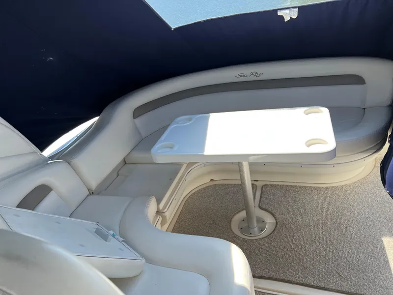 Slide: The Image of 2004 Sea Ray 340 Sundancer interior with cushioned seating and table under canopy. - 9