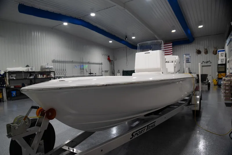 The Image of 2024 Contender 23 Bay boat on trailer in indoor showroom. - 0