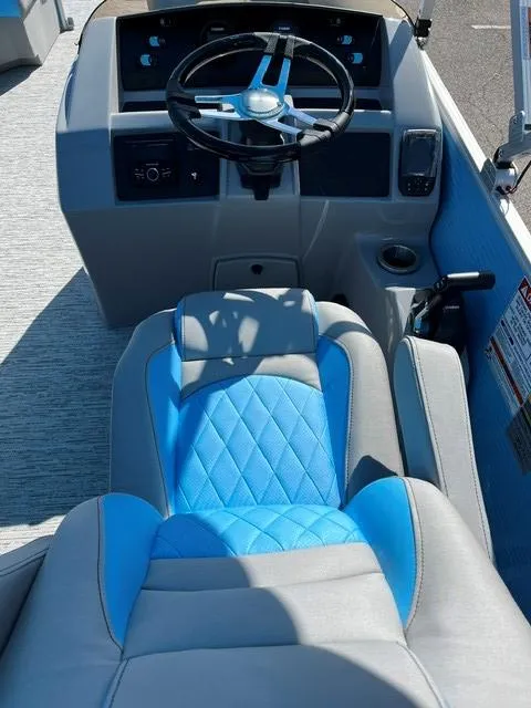 Slide: The Image of 2025 Bennington 20L Cruise boat interior with blue and gray seating and steering console. - 7