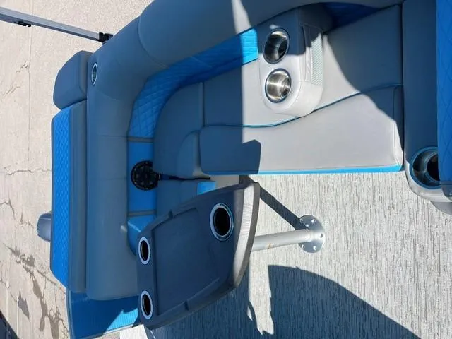 Slide: The Image of 2025 Bennington 20L Cruise boat interior with gray and blue seating, cup holders, and table. - 9