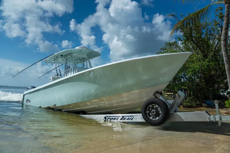 Slide: The Image of 2024 Contender 35 ST boat on trailer by the beach, under a clear blue sky. - 3