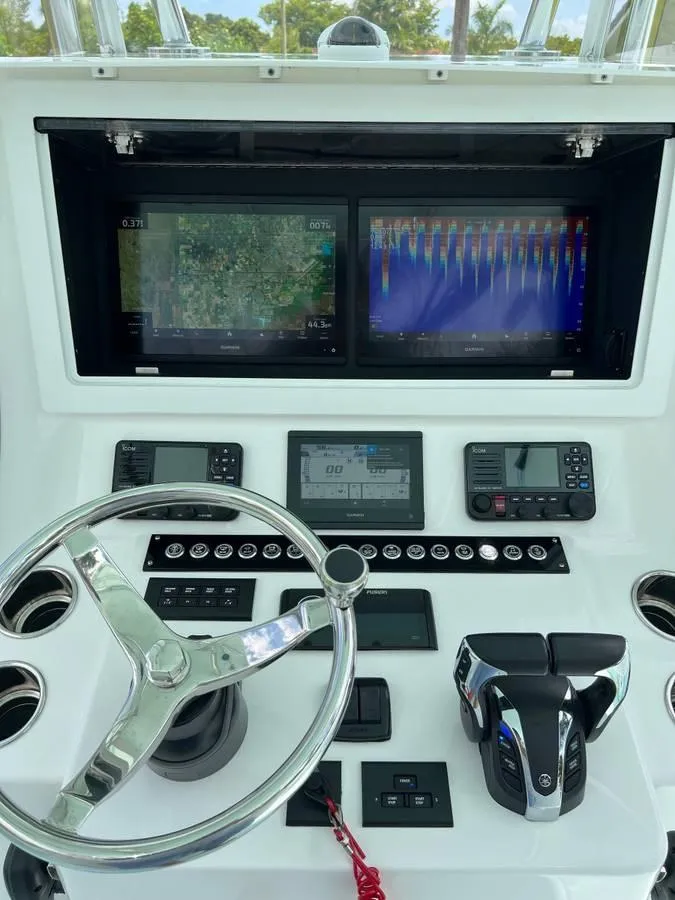 Slide: The Image of 2024 Contender 35 ST boat dashboard with dual screens and steering wheel. - 5