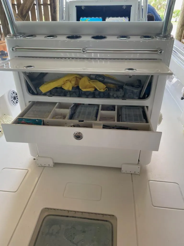 Slide: The Image of 2023 Contender 35 ST boat with open storage compartments and fishing gear. - 11