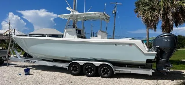 Slide: The Image of 2023 Contender 35 ST boat on trailer with Yamaha outboard, parked outdoors. - 2