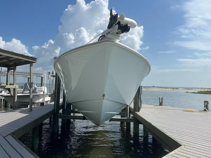 Slide: The Image of 2023 Contender 35 ST boat docked, viewed from the front, under a clear blue sky. - 26