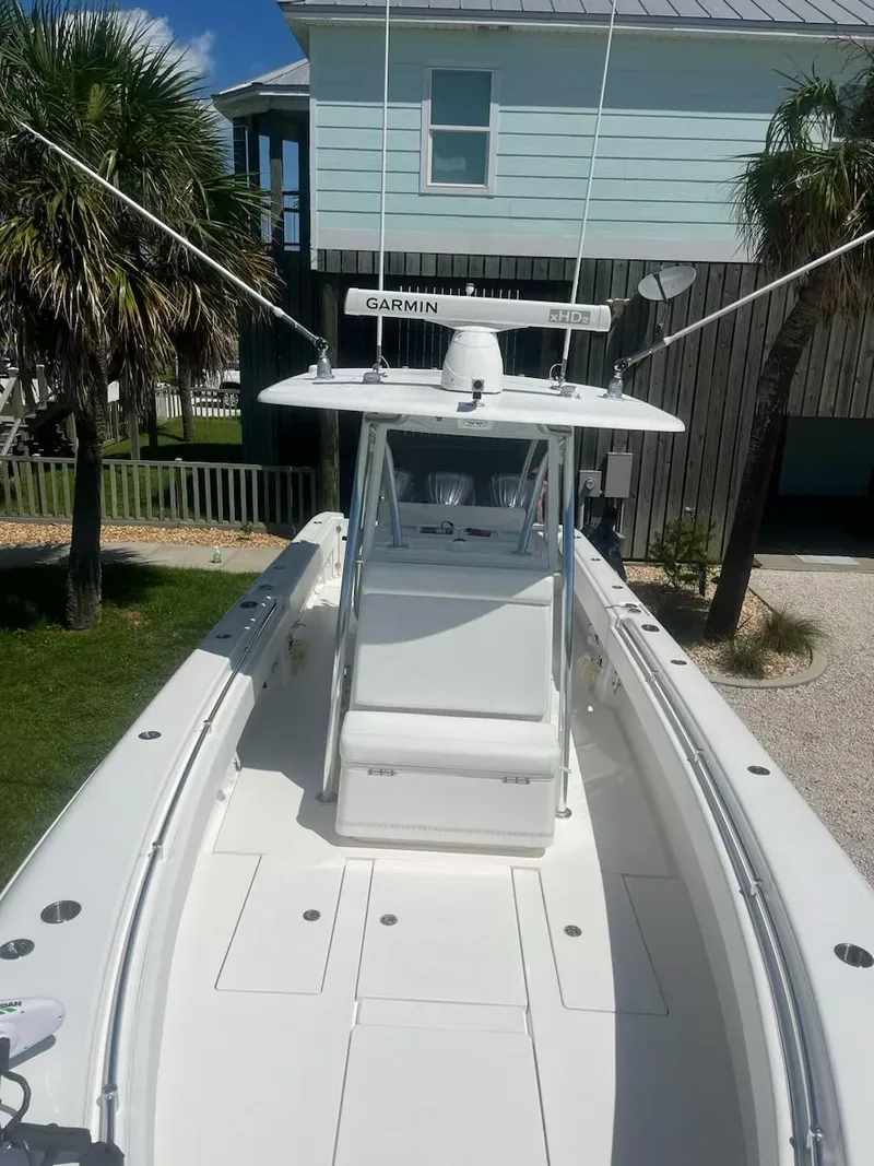 Slide: The Image of 2023 Contender 35 ST boat with Garmin equipment, docked near a coastal house. - 29