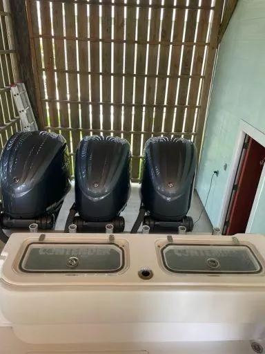 Slide: The Image of 2023 Contender 35 ST boat with triple outboard engines in a covered dock. - 34